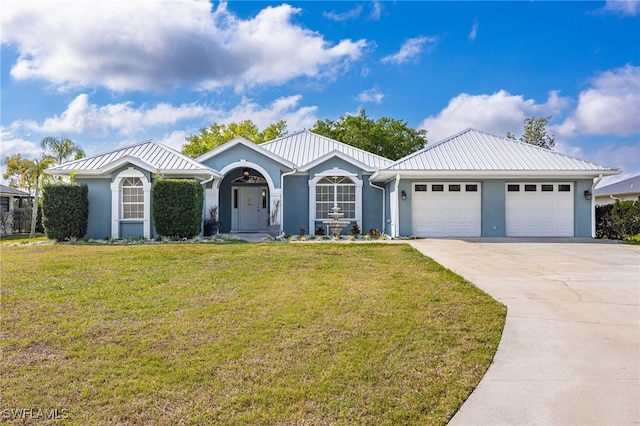 ranch-style house with stucco siding, a front yard, metal roof, a garage, and driveway