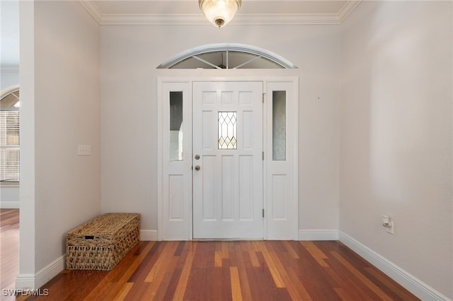 foyer featuring baseboards, wood finished floors, and crown molding