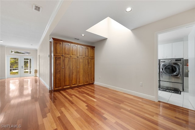 unfurnished living room with washer / dryer, visible vents, light wood-style floors, and french doors