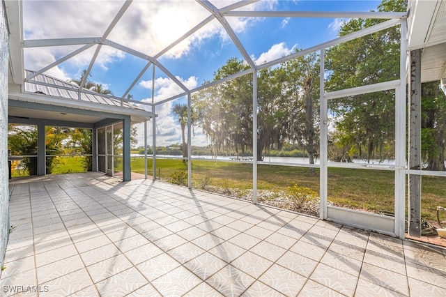 unfurnished sunroom featuring a water view