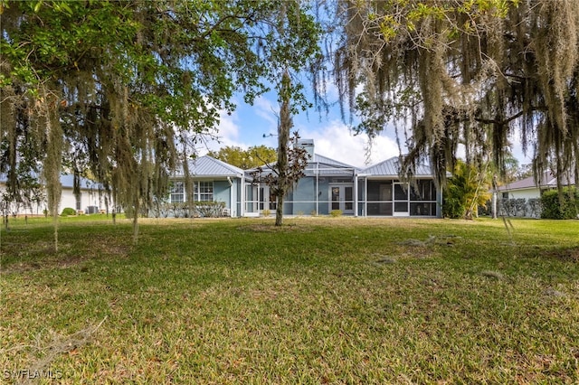 1261 Riverbend Dr, Labelle, FL 33935 - rear view of property featuring a lawn and metal roof