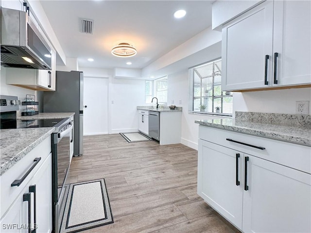 kitchen featuring recessed lighting, range with electric stovetop, visible vents, stainless steel dishwasher, and light wood-type flooring