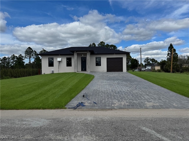 view of front of property featuring a garage, a front lawn, decorative driveway, and stucco siding