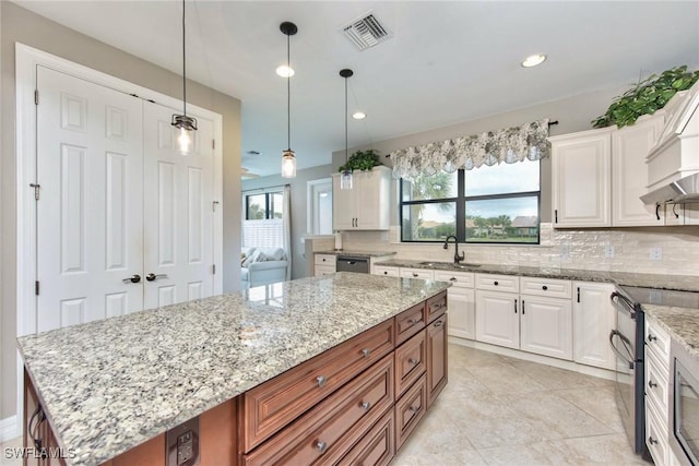 kitchen with brown cabinetry, stainless steel appliances, white cabinets, and a center island