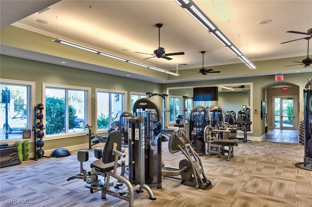 exercise room featuring light carpet, arched walkways, and baseboards