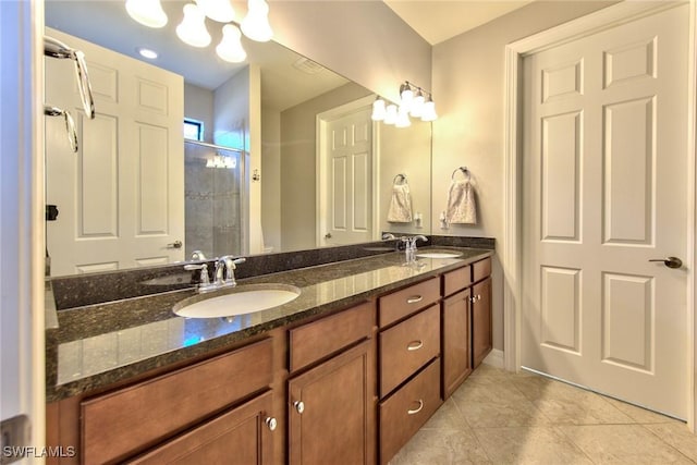 bathroom with double vanity, a stall shower, a sink, and tile patterned floors