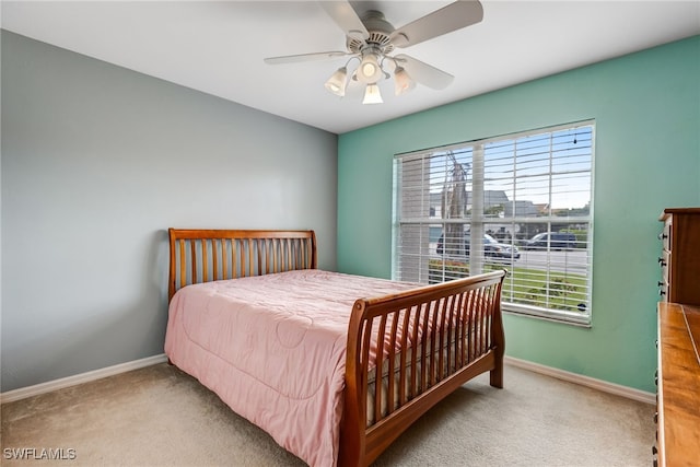 carpeted bedroom with a ceiling fan and baseboards