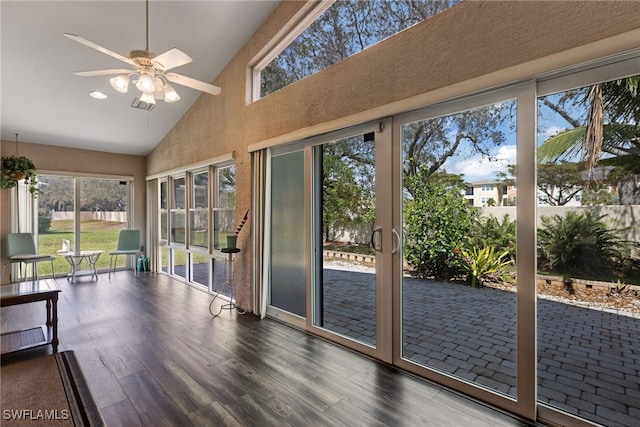 unfurnished sunroom featuring lofted ceiling, visible vents, and a ceiling fan