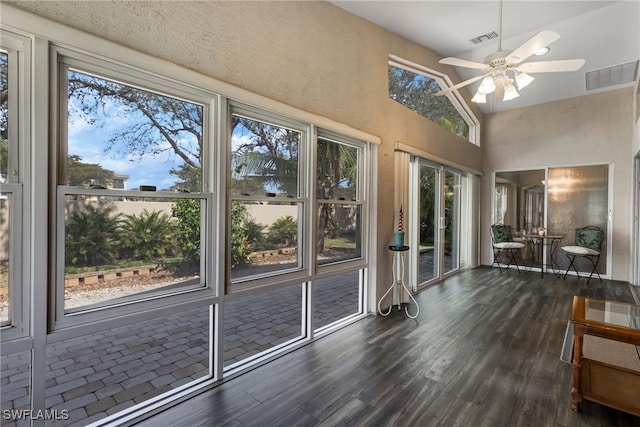 unfurnished sunroom featuring lofted ceiling, visible vents, and a ceiling fan