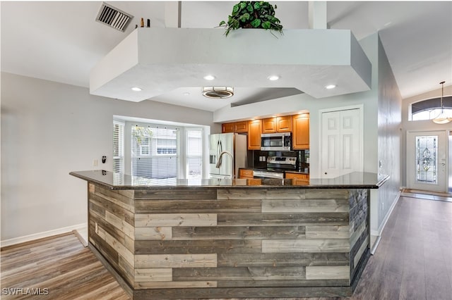 kitchen featuring light wood finished floors, visible vents, stainless steel appliances, and high vaulted ceiling