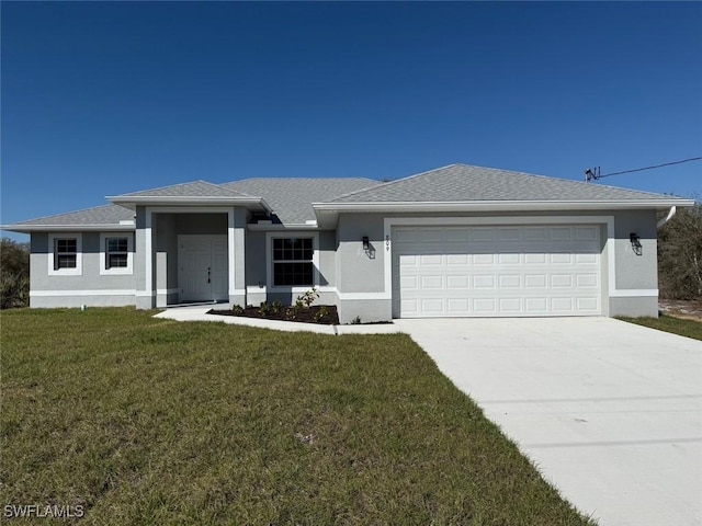 view of front facade featuring a garage, driveway, a front yard, and stucco siding