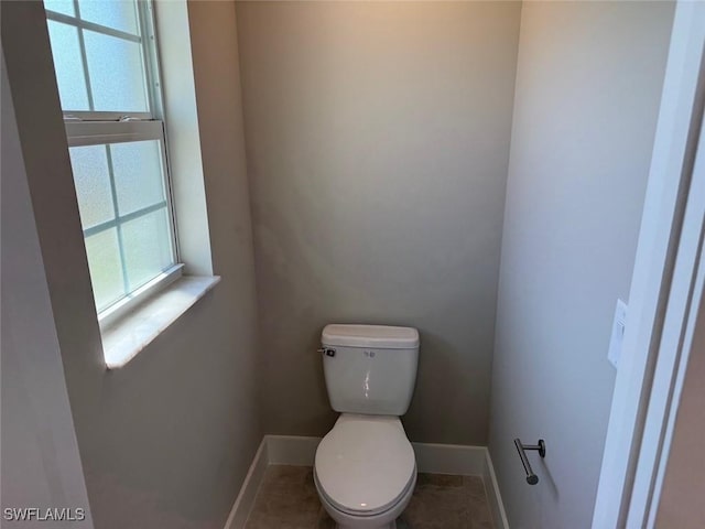 bathroom with toilet and baseboards