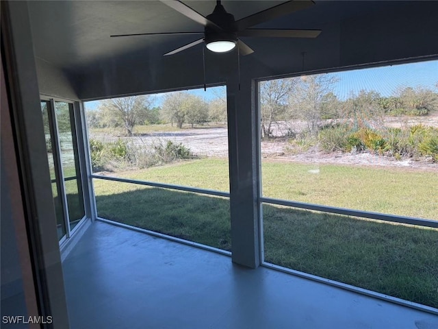 unfurnished sunroom featuring a ceiling fan