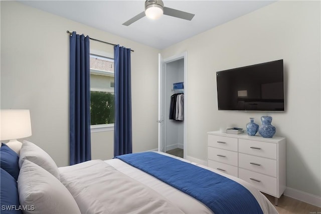 bedroom featuring a ceiling fan, baseboards, and wood finished floors