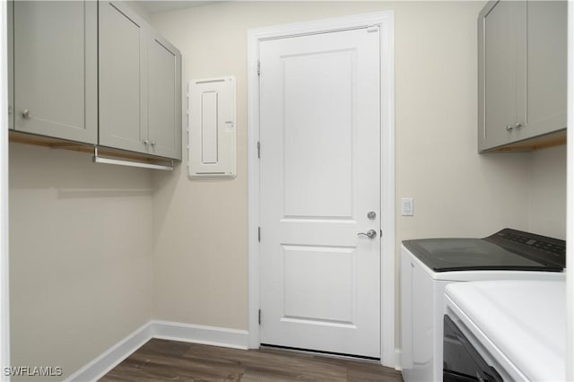 washroom with dark wood-type flooring, baseboards, washer and dryer, electric panel, and cabinet space