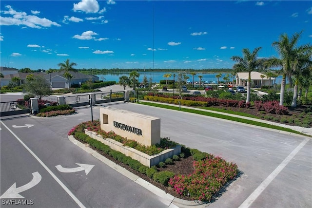 view of street with a water view, sidewalks, and a gate