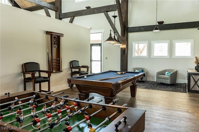 game room with billiards, wood finished floors, and a towering ceiling