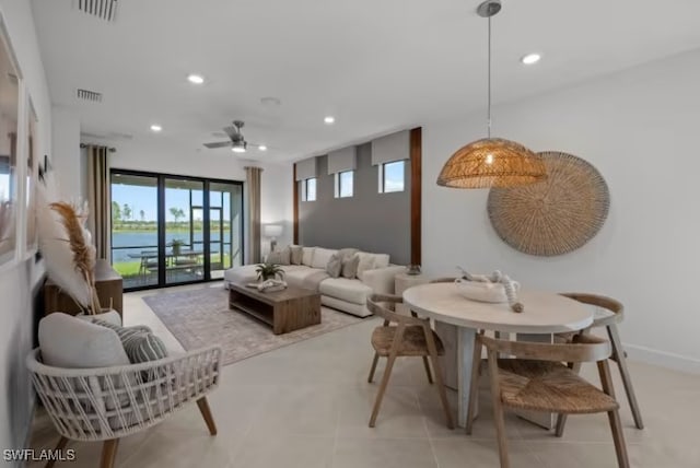 interior space with a water view, visible vents, a wall of windows, and recessed lighting