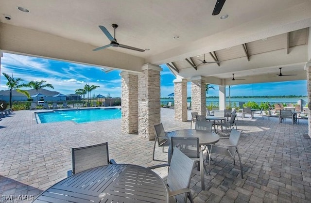 view of patio / terrace featuring ceiling fan, a community pool, and outdoor dining space