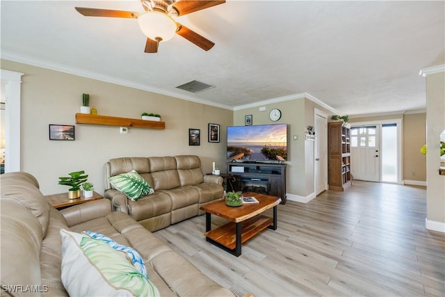 living area featuring ornamental molding, light wood-type flooring, visible vents, and baseboards