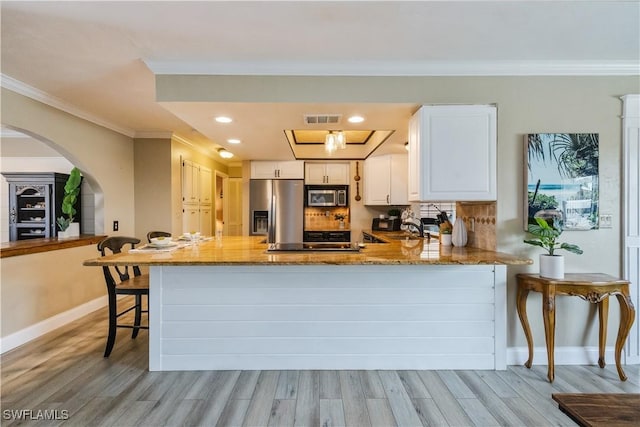 kitchen featuring stone countertops, stainless steel appliances, a peninsula, a sink, and visible vents