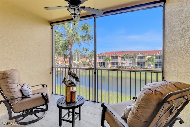 sunroom / solarium with a residential view and a ceiling fan