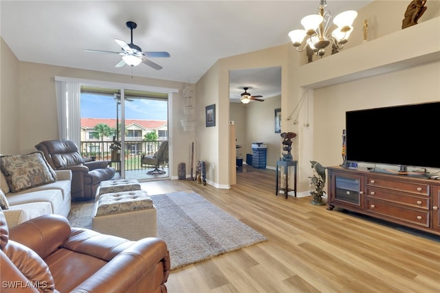 living area with lofted ceiling, light wood-style floors, baseboards, and ceiling fan with notable chandelier