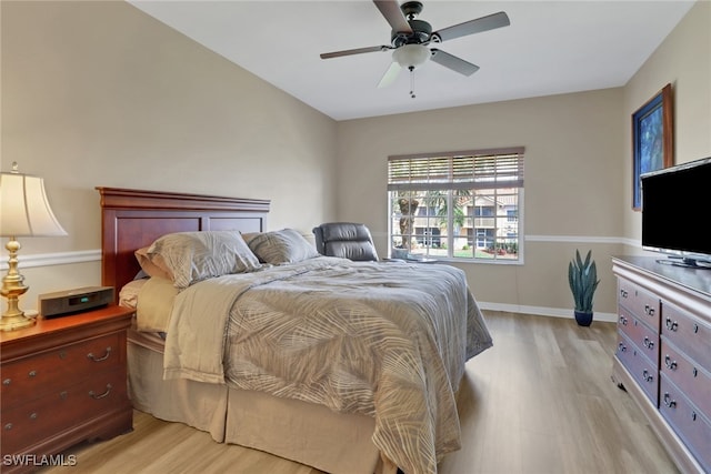 bedroom featuring light wood-style floors, baseboards, and a ceiling fan