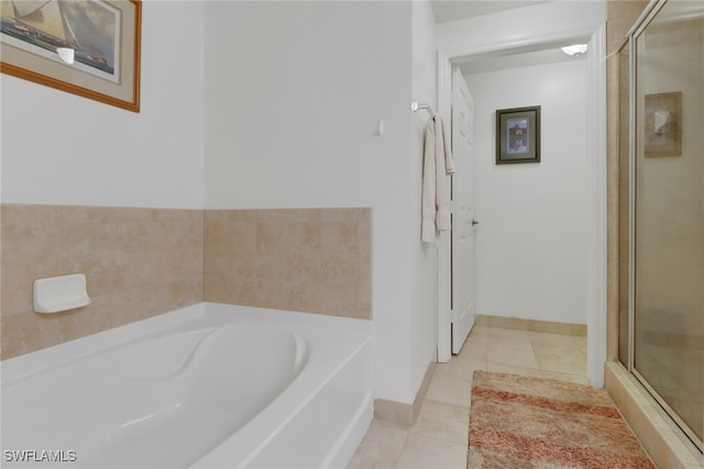 bathroom with tile patterned flooring, a shower stall, baseboards, and a bath