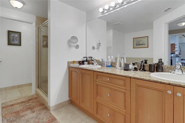 bathroom featuring tile patterned flooring, a sink, and a shower stall