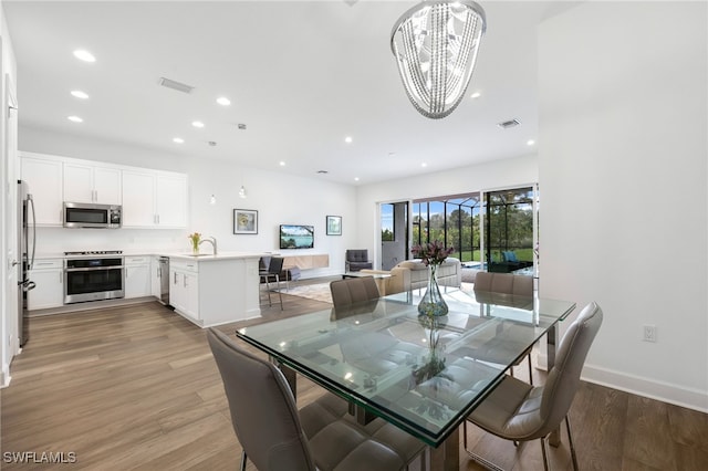 dining space featuring light wood-type flooring, visible vents, recessed lighting, and an inviting chandelier