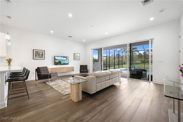 living area featuring recessed lighting, a sunroom, visible vents, and dark wood finished floors