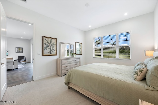 bedroom featuring light carpet, baseboards, and recessed lighting