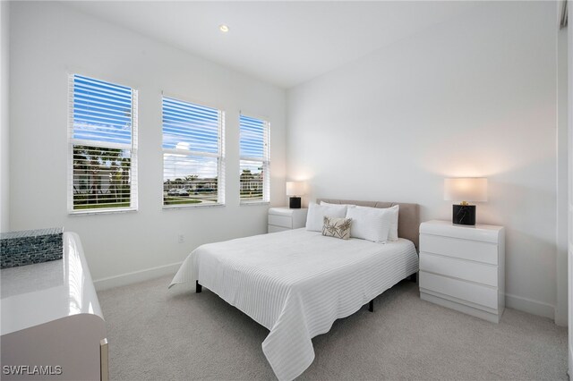 bedroom featuring baseboards and light colored carpet