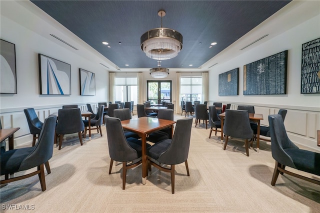 dining room with a tray ceiling, light colored carpet, and recessed lighting