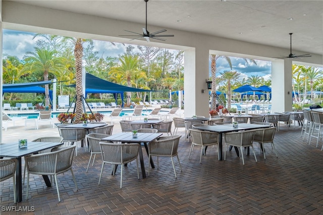 view of patio with a community pool and outdoor dining space