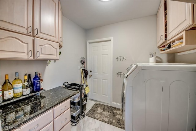 laundry area featuring cabinet space, baseboards, and washing machine and clothes dryer