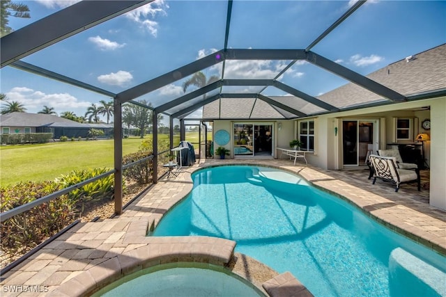 view of swimming pool with a lanai, a yard, a pool with connected hot tub, and a patio