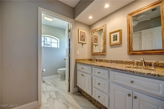 bathroom featuring marble finish floor, baseboards, a sink, and toilet