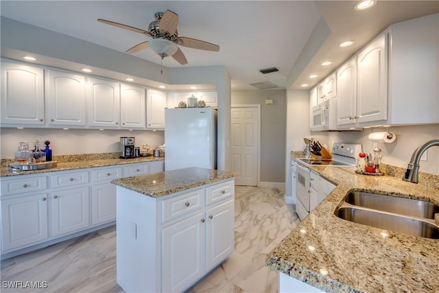 kitchen with white appliances, a kitchen island, marble finish floor, a sink, and recessed lighting