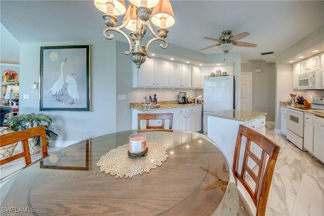 kitchen with light stone countertops, white appliances, marble finish floor, and white cabinets