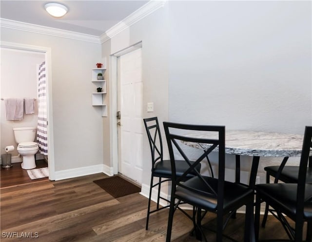 dining space with baseboards, dark wood finished floors, and crown molding