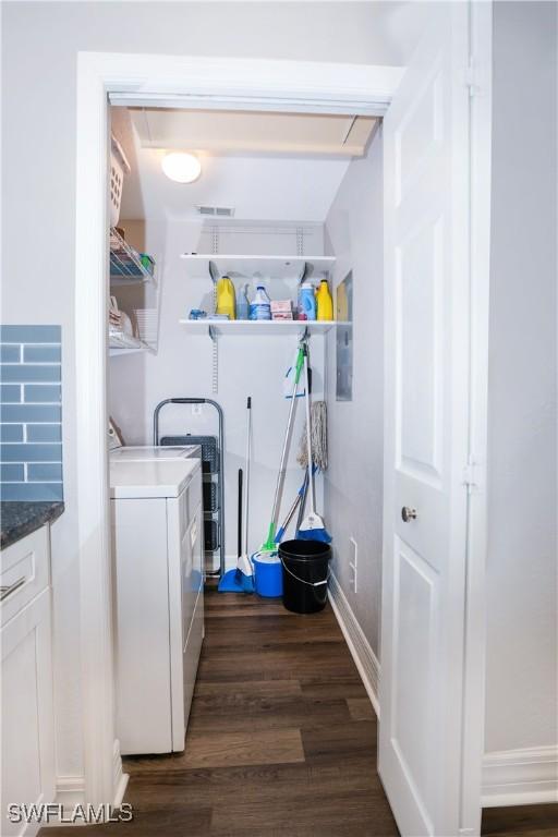 laundry area featuring dark wood-style floors, baseboards, and separate washer and dryer