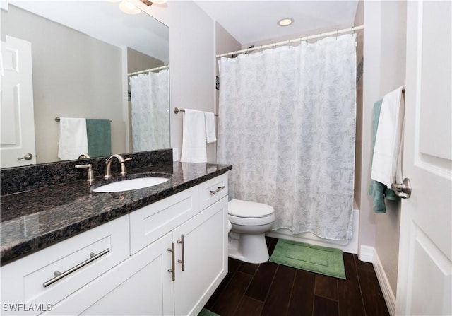 full bathroom with shower / tub combo, vanity, toilet, and wood finished floors