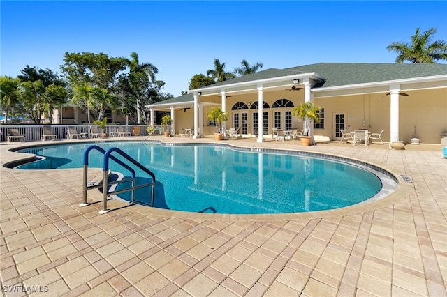 community pool with a patio area, ceiling fan, fence, and french doors