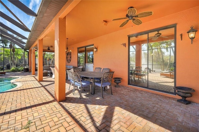 view of patio / terrace featuring a lanai, outdoor dining space, an outdoor pool, and a ceiling fan