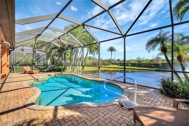 outdoor pool featuring glass enclosure, a patio, and a water view