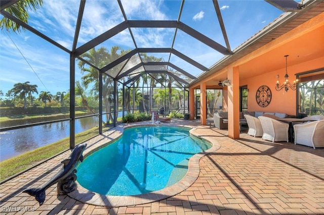 pool featuring outdoor lounge area, glass enclosure, a patio area, and a water view