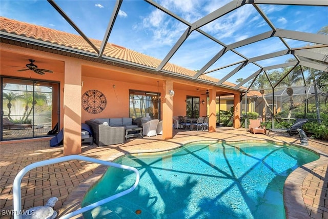 outdoor pool featuring ceiling fan, outdoor lounge area, glass enclosure, and a patio