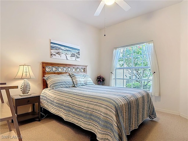 carpeted bedroom featuring baseboards and a ceiling fan